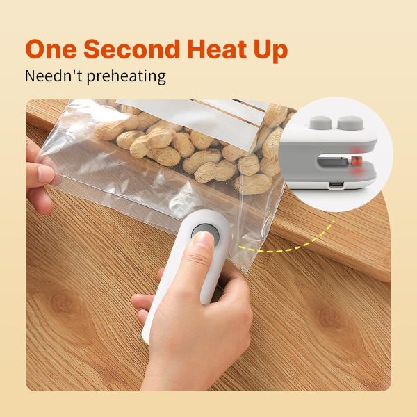 Hand using a hand-held vacuum sealer to seal a bag of peanuts on a wooden surface.